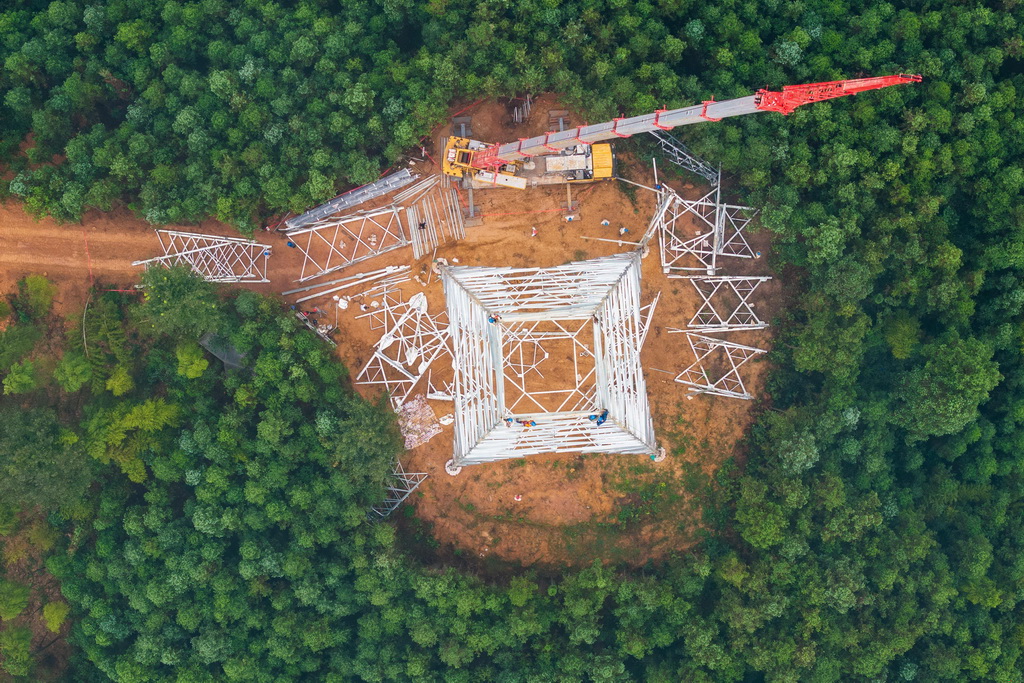 9月16日，在位于常德市桃源縣的“寧電入湘”工程沅江跨越施工現場，電力工人在進行組塔作業（無人機照片）。