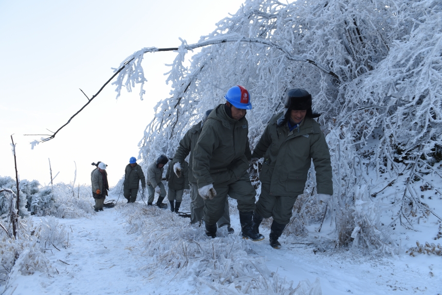 搶修人員在通往±800千伏陜武線1898號塔位路段，運送工器具和物資，開展設備調試，為覆冰桿塔后續除冰作業創造有利條件。李季攝