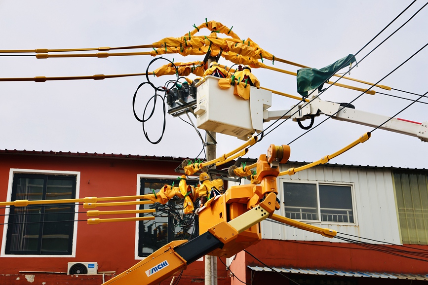 河南洛陽孟津供電公司帶電作業人員在10千伏麻水線開展帶電加裝柱上開關作業。劉偉韜 攝