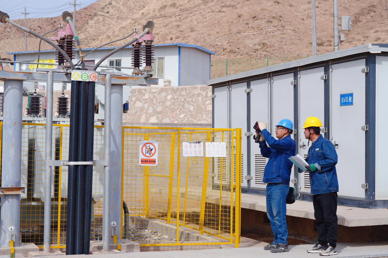 國網永靖縣供電公司員工協助永靖光輝扶貧光伏電站運維人員檢查站內供電設備安全運行情況。史雙絢 攝.png